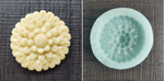 An unbaked cookie in the shape of a dahlia flower next to the Artesao Silicone Cookie Mold used to create it
