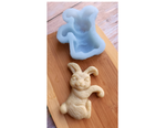 An unbaked bunny cookie and the blue Artesao Silicone Cookie Mold that made it on a light wood board